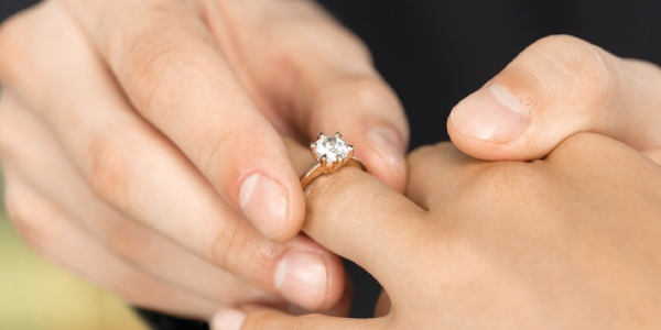 Representing A Man Wearing Engagement Ring on her Girl's Hand.