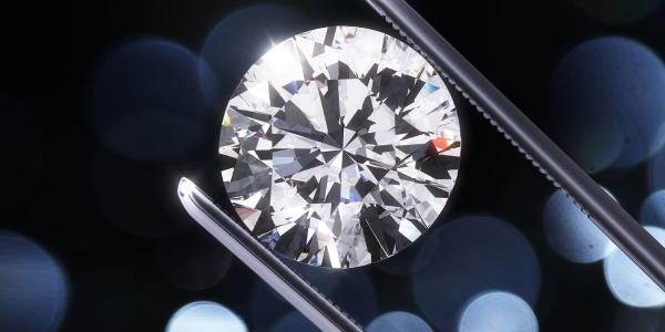 Brilliant Cut Diamond Held By Tweezers.