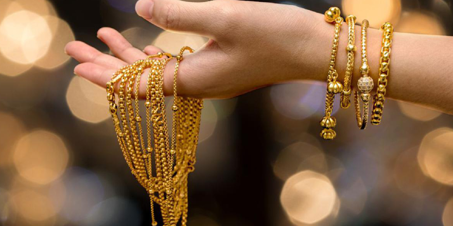 A Woman Holding Traditional Gold Chains.